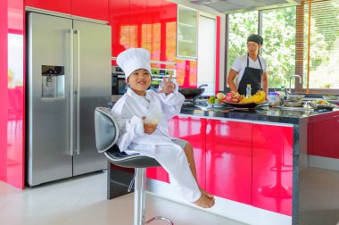 Tatlı Tay çocuğu şefin şapka ve yüksek c üzerinde oturan tunik