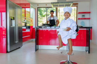 Tatlı Tay çocuğu şefin şapka ve yüksek c üzerinde oturan tunik