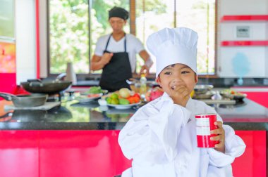 Tatlı Tay çocuğu şefin şapka ve yüksek c üzerinde oturan tunik