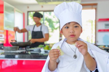 Tatlı Tay çocuğu şefin şapka ve yüksek c üzerinde oturan tunik