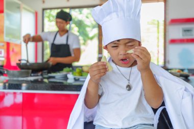 Tatlı Tay çocuğu şefin şapka ve yüksek c üzerinde oturan tunik
