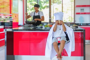 Tatlı Tay çocuğu şefin şapka ve yüksek c üzerinde oturan tunik