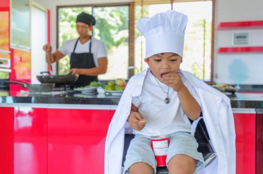 Tatlı Tay çocuğu şefin şapka ve yüksek c üzerinde oturan tunik