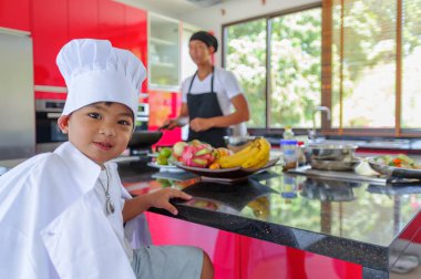Tatlı Tay çocuğu şefin şapka ve yüksek c üzerinde oturan tunik