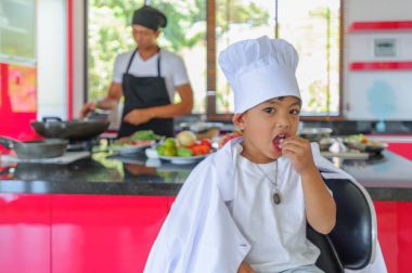 Tatlı Tay çocuğu şefin şapka ve yüksek c üzerinde oturan tunik