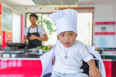 Tatlı Tay çocuğu şefin şapka ve yüksek c üzerinde oturan tunik
