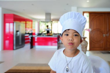 Tatlı Tay çocuğu şefin şapka ve yüksek c üzerinde oturan tunik