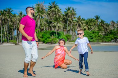 Üç tropikal plaj, gülen ve e çalışan aile
