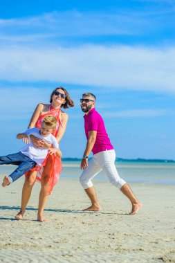 Üç tropikal plaj, gülen ve e çalışan aile