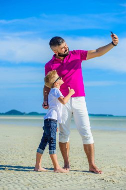 Mutlu baba ve oğul tropikal plaj, gülen ve enjoing