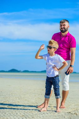 Mutlu baba ve oğul tropikal plaj, gülen ve enjoing