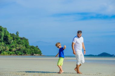 Mutlu baba ve oğul tropikal plaj, gülen ve enjoing