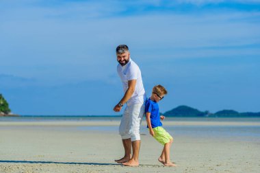Mutlu baba ve oğul tropikal plaj, gülen ve enjoing