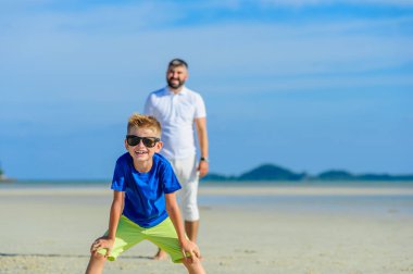 Mutlu baba ve oğul tropikal plaj, gülen ve enjoing