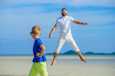 Mutlu baba ve oğul tropikal plaj, gülen ve enjoing
