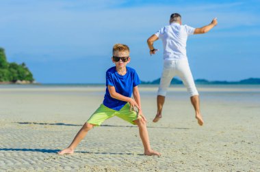 Mutlu baba ve oğul tropikal plaj, gülen ve enjoing