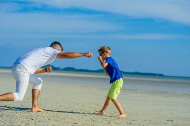 Mutlu baba ve oğul tropikal plaj, gülen ve enjoing