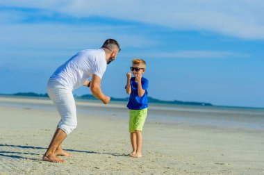 Mutlu baba ve oğul tropikal plaj, gülen ve enjoing