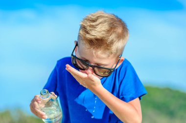 Güneş gözlüğü içme suyu susuz yakışıklı bir çocuk portresi 