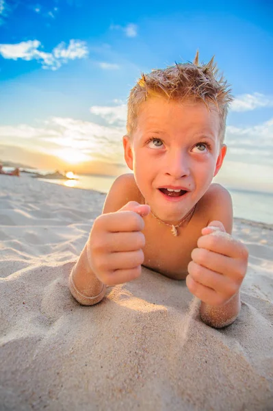 Yakışıklı sekiz yıl çocuk sahilde gerçekleştirir akrobatik çizimler bir