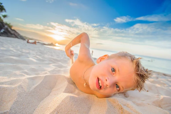 Yakışıklı sekiz yıl çocuk sahilde gerçekleştirir akrobatik çizimler bir