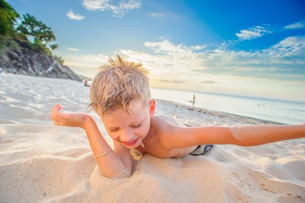 Yakışıklı sekiz yıl çocuk sahilde gerçekleştirir akrobatik çizimler bir