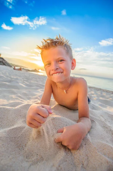 Yakışıklı sekiz yıl çocuk sahilde gerçekleştirir akrobatik çizimler bir