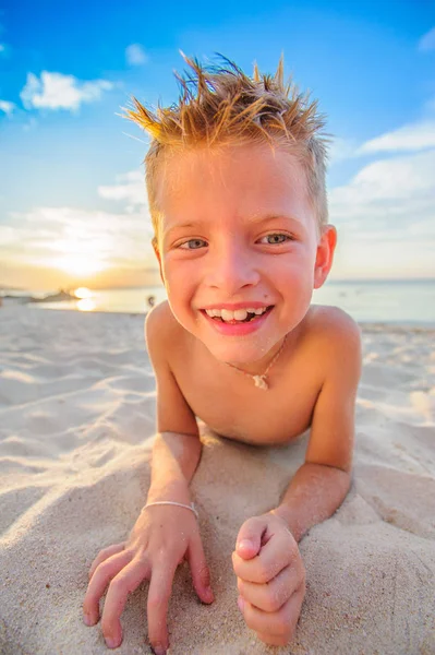 Knappe jongen van acht jaar op strand voert acrobatische schetsen een — Stockfoto