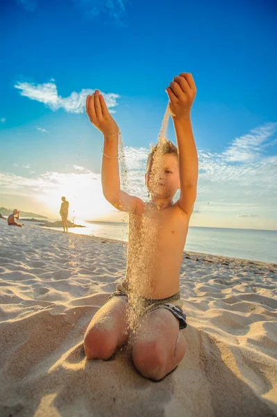 Yakışıklı sekiz yıl çocuk sahilde gerçekleştirir akrobatik çizimler bir