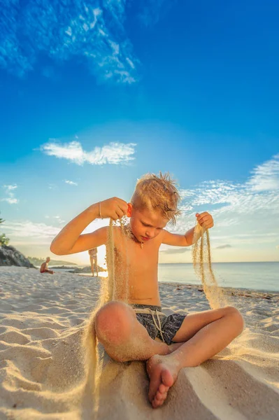 Yakışıklı sekiz yıl çocuk sahilde gerçekleştirir akrobatik çizimler bir