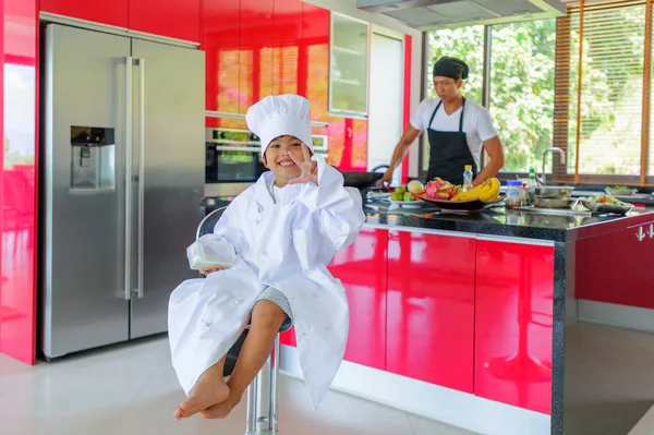 Tatlı Tay çocuğu şefin şapka ve yüksek c üzerinde oturan tunik