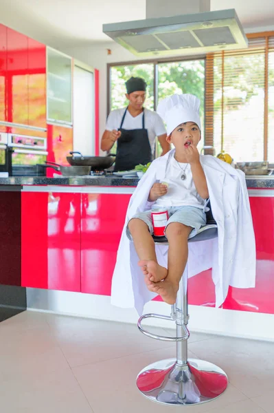 Tatlı Tay çocuğu şefin şapka ve yüksek c üzerinde oturan tunik