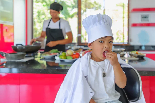 Tatlı Tay çocuğu şefin şapka ve yüksek c üzerinde oturan tunik
