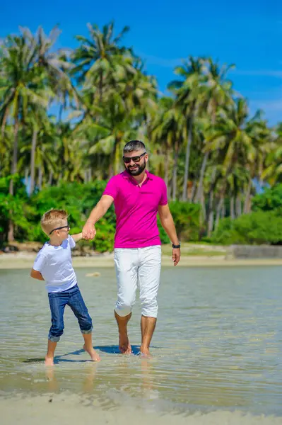 Baba ve oğul tropik sahil boyunca çalışan