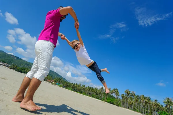 Mutlu baba ve oğul tropikal plaj, gülen ve enjoing