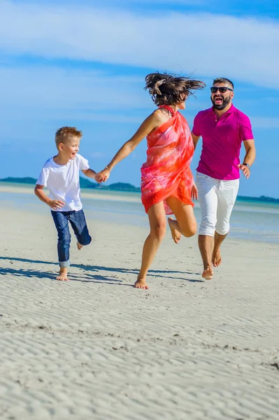 Familia de tres corriendo y saltando por la playa tropical, la — Foto de Stock