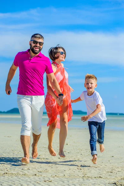 Familia de tres corriendo y saltando por la playa tropical, la — Foto de Stock