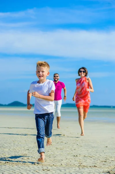 Çocuk ve ailesi çalıştıran ve tropik sahil boyunca atlama