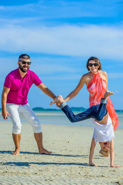 Üç tropikal, mutlu aile plaj, gülüyor ve emretmek