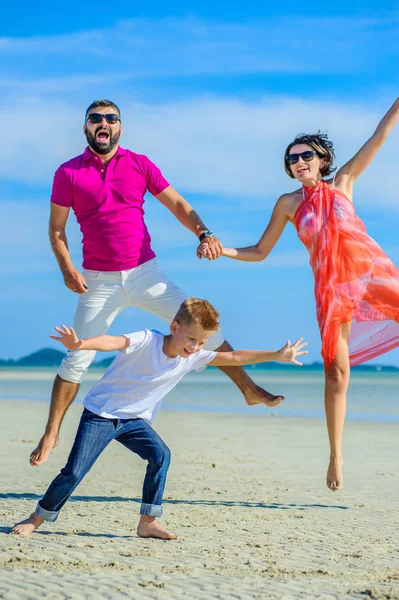 Üç tropikal, mutlu aile plaj, gülüyor ve emretmek