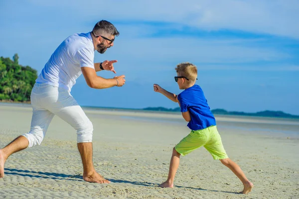 Mutlu baba ve oğul tropikal plaj, gülen ve enjoing