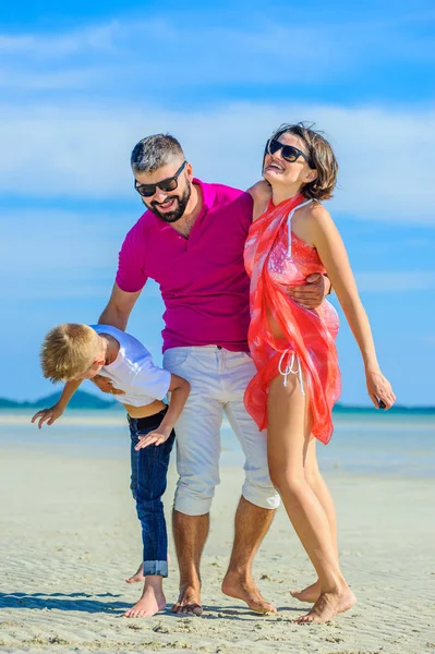 Üç tropikal, mutlu aile plaj, gülüyor ve emretmek