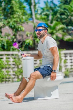 Gözlük installe olan tuvalet, ata biner gibi sakallı adam