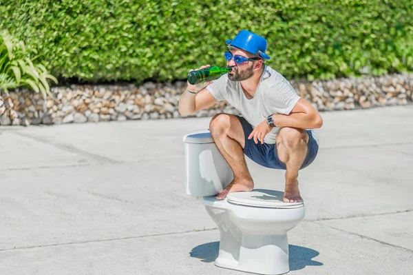The bearded man in goggles astride the toilet, which is installe — Stock Photo, Image