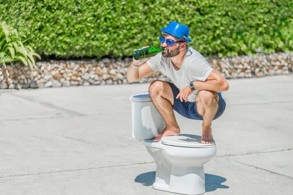 De bebaarde man in bril schrijlings op het toilet, oftewel installe — Stockfoto