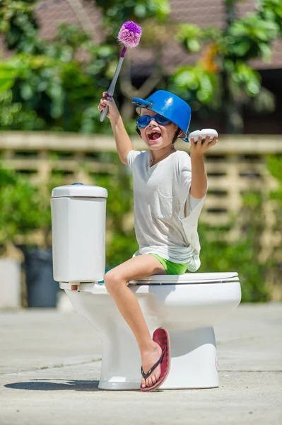 Absurd picture - montar um banheiro: menino bonito em óculos sentados o — Fotografia de Stock