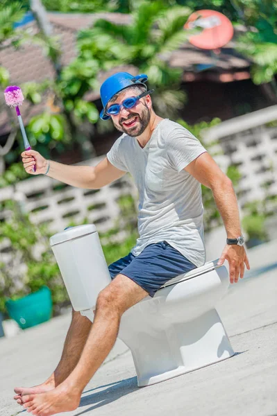 Gözlük installe olan tuvalet, ata biner gibi sakallı adam