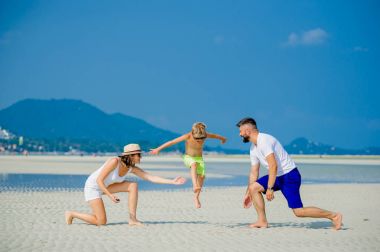 Üç çöl güneşli kumsalda eğleniyor mutlu genç aile