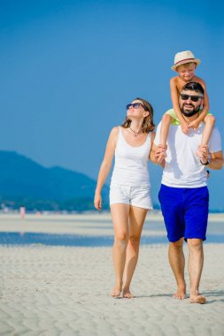 Üç çöl güneşli kumsalda eğleniyor mutlu genç aile