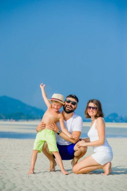 Üç çöl güneşli kumsalda eğleniyor mutlu genç aile